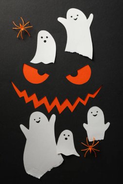 Siyah arkaplanda örümcekler ve kağıt hayaletler, üst görünüm