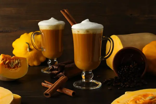 Pumpkin coffee, cinnamon and pumpkins on wooden background