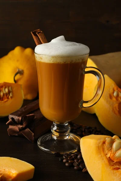 Pumpkin coffee, gift box and pumpkins on wooden background