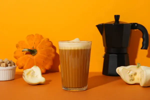 Pumpkin coffee and zucchini on orange background