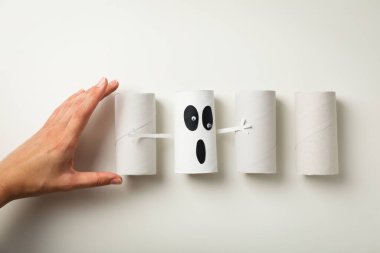 Kağıt hayalet, kollar ve beyaz arka planda kadın eli, üst görünüm