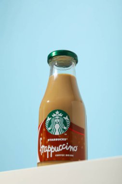 Ukrayna, Kyiv, 24 / 08 / 2023: Mavi arkaplanlı Starbucks frappuccino şişesi.