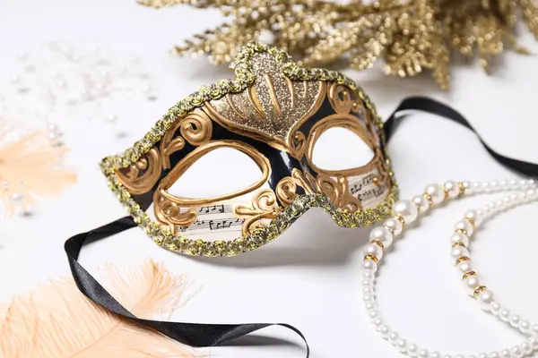 Beyaz arka planda karnaval maskesi ve dekor, kapatın.