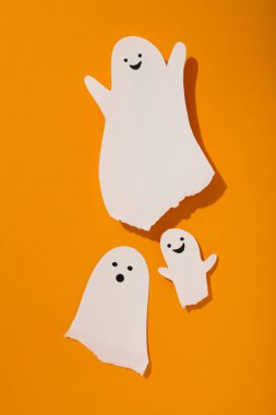 Turuncu arka planda kağıt hayaletler, üst görünüm