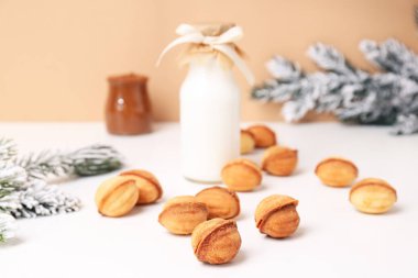 Bir şişe süt ve Noel ağacı dallı fındık kurabiyesi.