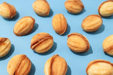 Mavi arka planda fındık şeklinde kurabiyeler.