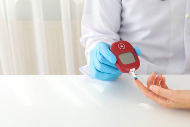 Doktor kan şekerini glukometre kullanarak ölçüyor. Diyabet tedavisi kavramı.