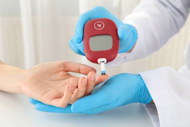 Doktor kan şekerini glukometre kullanarak ölçüyor. Diyabet tedavisi kavramı.