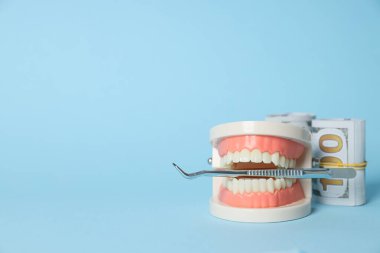 Dekoratif çene, cımbız ve para mavi arkaplan, metin için boşluk