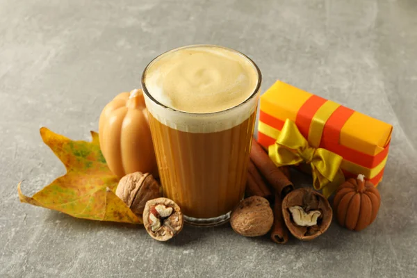 Pumpkin coffee, leaf and cinnamon on gray background