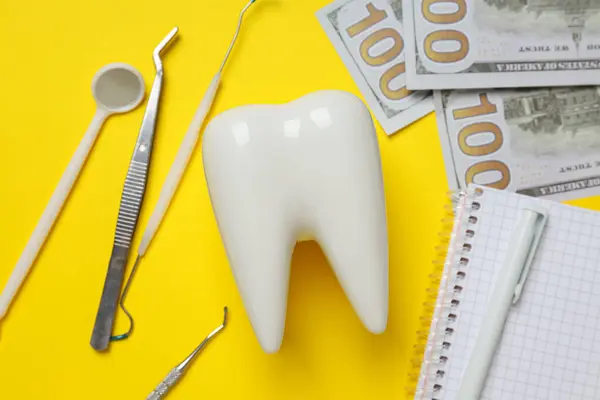 Οδοντιατρικά Εργαλεία Χρήματα Διακοσμητικά Δόντια Και Σημειωματάριο Κίτρινο Φόντο Closeup — Φωτογραφία Αρχείου