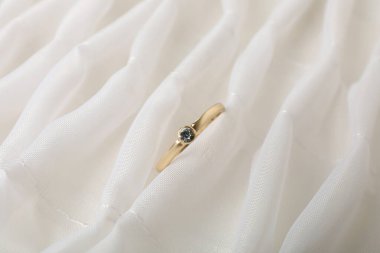 Hafif bir arkaplanda altın bir nişan yüzüğü..