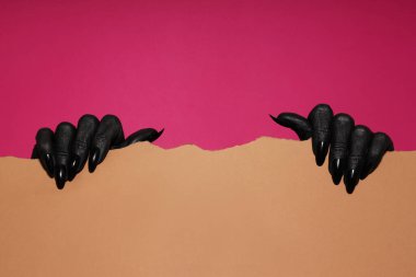 Siyah eller kağıdı tutuyor, pembe arka planda..