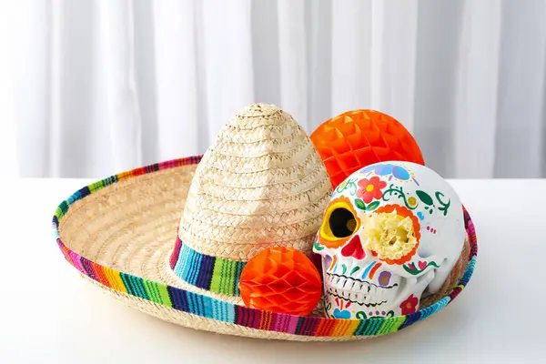 軽い背景のソンブレロのメキシコの頭蓋骨と紙のボール — ストック写真