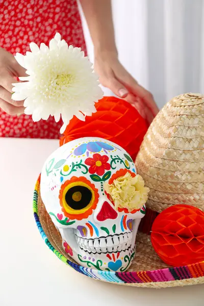 メキシコの頭蓋骨 ソンブレロの紙ボール 明るい背景に花を持つ女性 — ストック写真