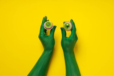 Gözleri yeşil, elleri sarı arka planda