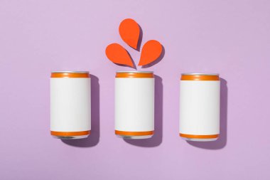 Teneke kutular ve kağıt damlaları mor arka planda, üst görünümde