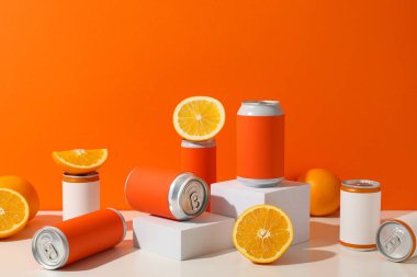 Turuncu arka planda teneke ve portakallar