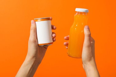 Cam şişe ve portakal suyu dolu teneke kutu.