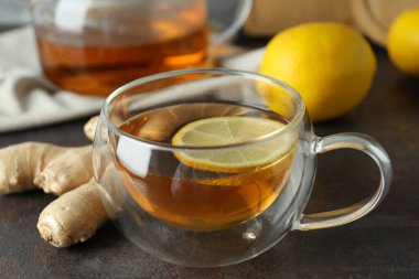 Gri arka planda çay, limon ve zencefil, yakın plan.