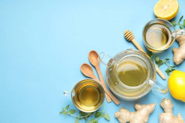 Bardaklar ve çaydanlıklar çay, limon, mavi arka planda zencefil, metin için yer