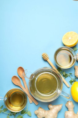 Bardaklar ve çaydanlıklar çay, limon, mavi arka planda zencefil, metin için yer