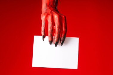 Canavarın ürkütücü, kırmızı elleri beyaz bir çarşaf tutuyordu.