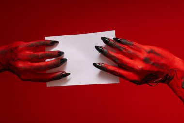 Canavarın ürkütücü, kırmızı elleri beyaz bir çarşaf tutuyordu.