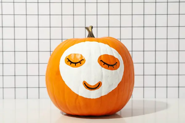 Pumpkin with face mask. Face care concept