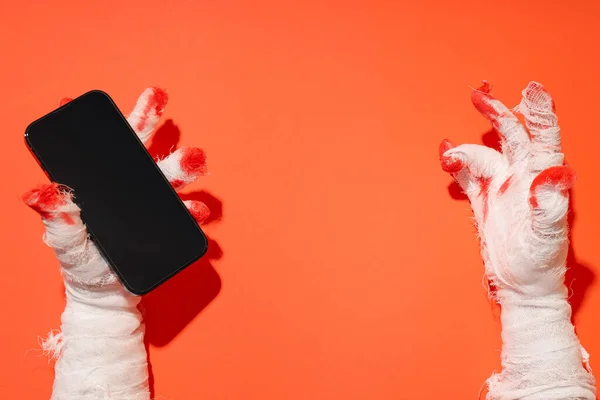 Hands wrapped in a bandage hold a smartphone