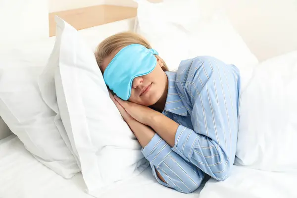 A young woman sleeps in a sleep mask