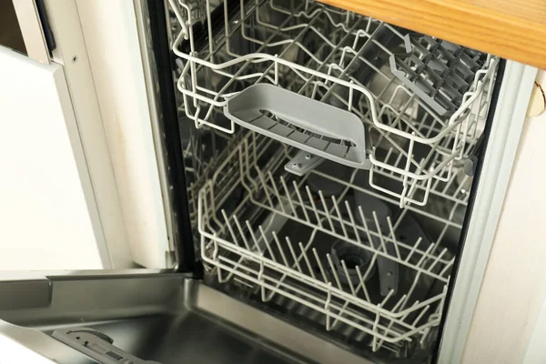 Open dishwasher with metal shelves for dishes