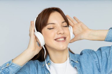 Çekici genç kız kulaklıkla müzik dinliyor.