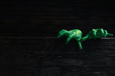 Koyu tahta arka planda yeşil kadın eli, metin için boşluk