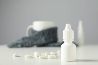 Arka planda haplar olan bir ilaç şişesinin yanında.