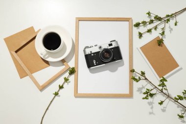 Klasik kamera, fotoğraf çerçeveleri ve beyaz arka planda fincan, üst görünüm