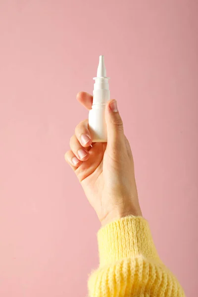 Nasal spray in hand. Concept of winter medicine