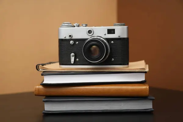 褐色背景木制桌子上的老式相机和记事本 — 图库照片