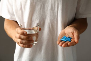 Bir adamın elinde mavi viagra hapları