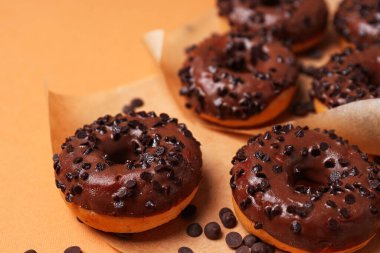 Turuncu arka planda çikolatalı çörekler.