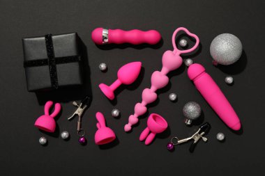 Karanlık arka planda Noel süslemeleri olan seks oyuncakları.