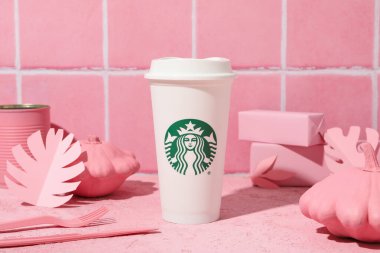 Ukrayna, Kyiv, 24 / 08 / 2023: Pembe arka planda bir fincan Starbucks kahvesi.