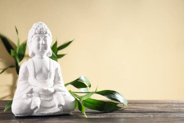 Buda heykeli ve bambu bej arka plandaki ahşap masa, metin için boşluk