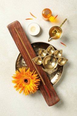 Bakır kaplar, çiçek, mum ve tütsü bej arka planda, üst görünümde.