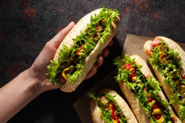 Kağıt üzerinde sosisliler ve koyu gri arka planda sosisliler.