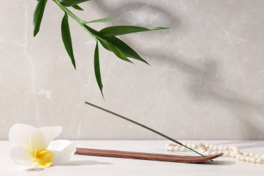 Çiçek, tütsü çubuğu ve bej arka planda bambu.