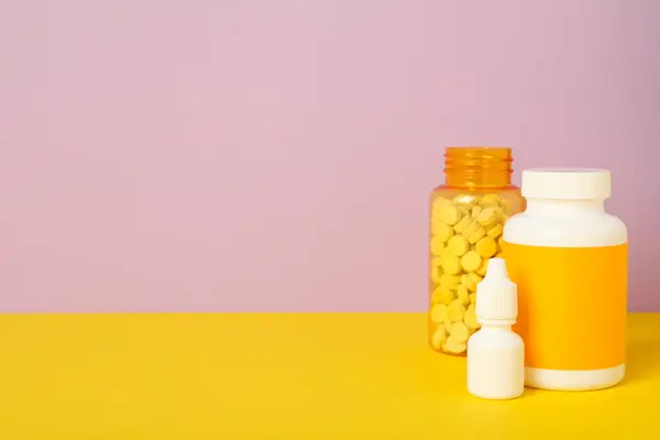 Jars with medicine on a yellow background