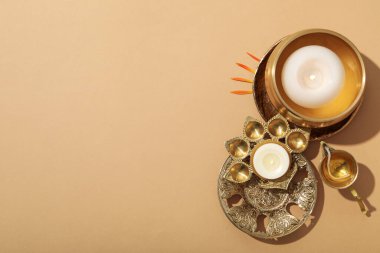 Bakır oryantal kaplar, bej arka planda bir şişe yağ ve mumlar, metin için yer