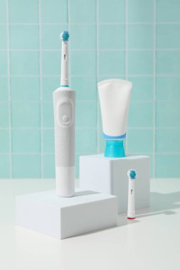 Elektrikli diş fırçası, mavi arkaplanda bloklar üzerine tüp