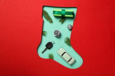 Anahtarı ve yılbaşı süslemeleri olan bir araba. Yeni yıl ayakkabısının siluetinde..